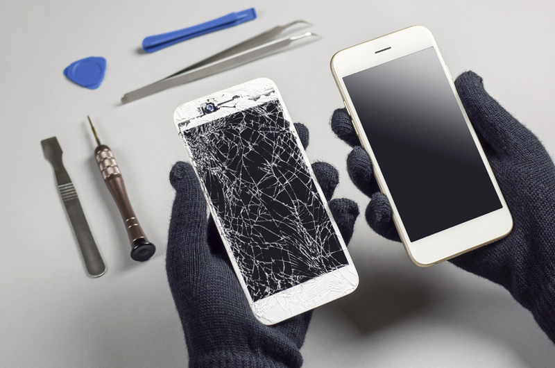 Smartphone Display Reparatur: kaputtes Handy und Ersatzgerät mit Werkzeug