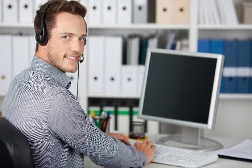 Mitarbeiter im Büro mit Headset am Computer, Kundenservice und Support﻿